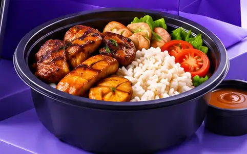 Bol de poulet grillé, riz, plantains et légumes avec une sauce à côté